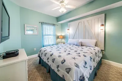 a bedroom with a bed with a white comforter at Majestic Beach Towers 2-603 in Panama City Beach