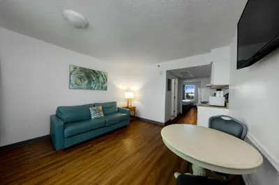 a living room with a table and a couch at Beachcomber Beachfront Hotel, a By The Sea Resort in Panama City Beach