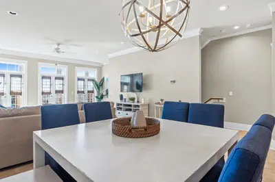 a dining room with a table and blue chairs at Glory Daze Beach House by Panhandle Gateways in Sunnyside
