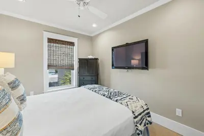 a bedroom with a bed and a flat screen tv at Glory Daze Beach House by Panhandle Gateways in Sunnyside