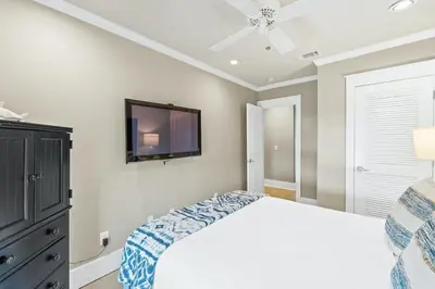 a bedroom with a bed and a tv on the wall at Glory Daze Beach House by Panhandle Gateways in Sunnyside