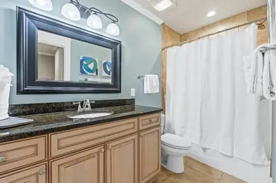 a bathroom with a sink and a toilet and a mirror at Glory Daze Beach House by Panhandle Gateways in Sunnyside