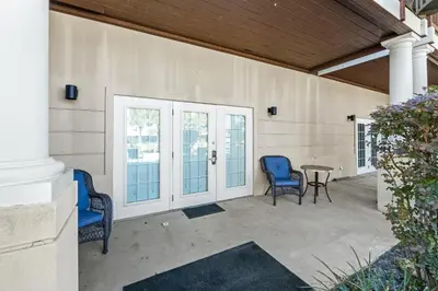 a patio with two blue chairs and a table at Glory Daze Beach House by Panhandle Gateways in Sunnyside