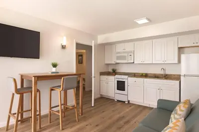 a kitchen with white cabinets and a table with chairs at Radisson Beachfront Hotel - Panama City Beach in Panama City Beach