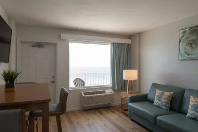 a living room with a couch and a table and a window at Radisson Beachfront Hotel - Panama City Beach in Panama City Beach