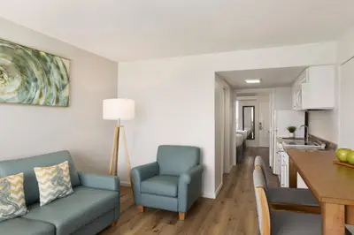 a living room with a blue couch and a kitchen at Radisson Beachfront Hotel - Panama City Beach in Panama City Beach