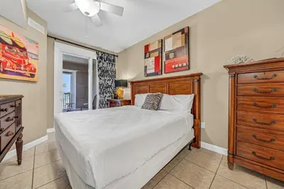 a bedroom with a large bed and a dresser at Grand Panama 1-303 in Panama City Beach