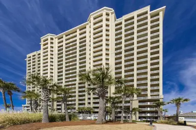 a large building with palm trees in front of it at Grand Panama 1-303 in Panama City Beach