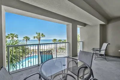 a balcony with a glass table and chairs and the ocean at Grand Panama 1-303 in Panama City Beach