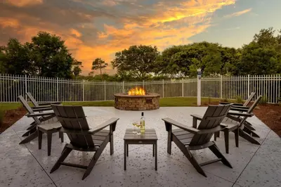 a fire pit with four chairs and a table with a bottle of wine at Marriott's Legends Edge at Bay Point in Panama City Beach