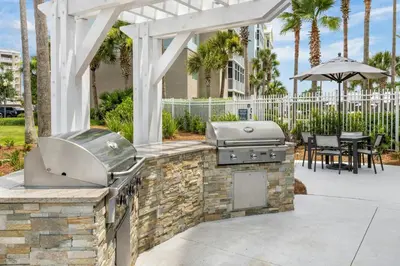 a patio with an outdoor grill with a table and chairs at Marriott's Legends Edge at Bay Point in Panama City Beach