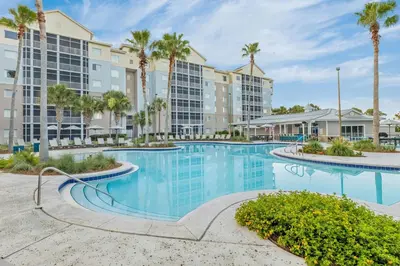 a swimming pool with palm trees and buildings at Marriott's Legends Edge at Bay Point in Panama City Beach