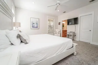a white bedroom with a large bed and a ceiling fan at 30A Beach House - Mar Chiquita in Watersound Beach