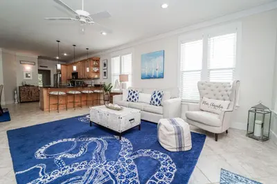 a living room with a couch and a blue rug at 30A Beach House - Mar Chiquita in Watersound Beach