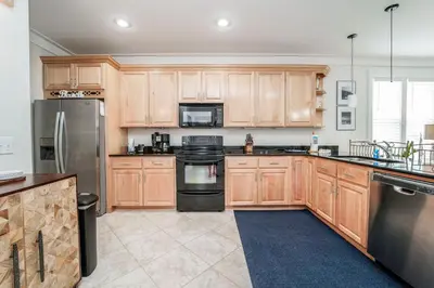 a kitchen with wooden cabinets and stainless steel appliances at 30A Beach House - Mar Chiquita in Watersound Beach