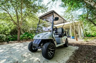 a golf cart parked in front of a house at 30A Beach House - Mar Chiquita in Watersound Beach