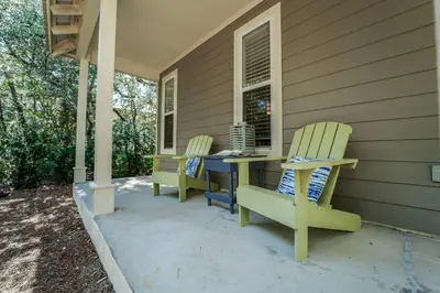 two chairs and a table on the porch of a house at 30A Beach House - Mar Chiquita in Watersound Beach