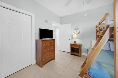 a bedroom with a bunk bed and a television at Sunrise Beach #2411 in Panama City Beach