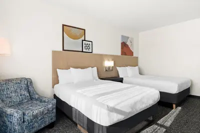a hotel room with two beds and a chair at Spark by Hilton Panama City Beach in Panama City Beach