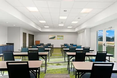 a classroom with tables and chairs in a room at Spark by Hilton Panama City Beach in Panama City Beach