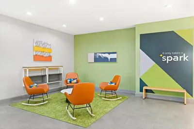 a waiting room with orange chairs and a wall at Spark by Hilton Panama City Beach in Panama City Beach