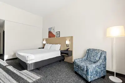 a hotel room with a bed and a chair at Spark by Hilton Panama City Beach in Panama City Beach