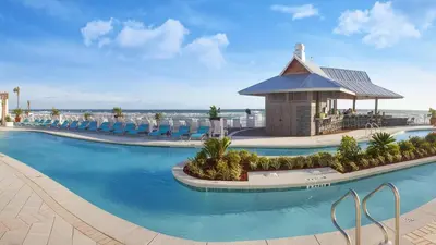 a resort swimming pool with chairs and a gazebo at Holiday Inn Express & Suites Panama City Beach - Beachfront by IHG in Panama City Beach