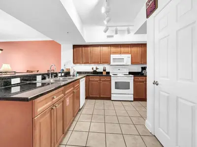 a large kitchen with wooden cabinets and white appliances at Emerald Beach 2225 in Panama City Beach