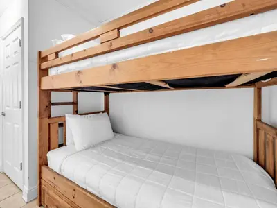 a bedroom with a bunk bed with white sheets at Emerald Beach 2225 in Panama City Beach