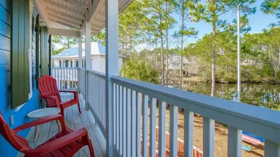 a porch with two chairs and a view of the water at The Bungalows at Seagrove 114 in Seagrove Beach