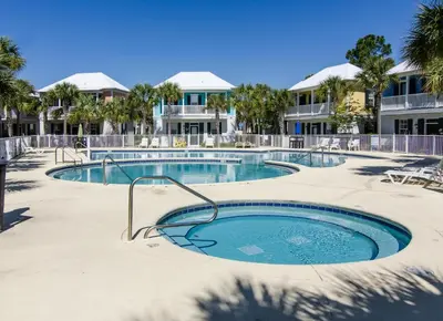 a swimming pool in a resort with palm trees at The Bungalows at Seagrove 114 in Seagrove Beach