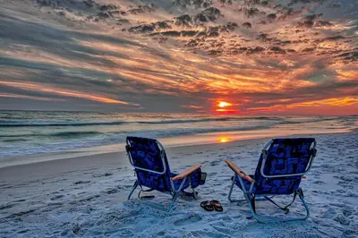 two chairs sitting on the beach at sunset at The Bungalows at Seagrove 114 in Seagrove Beach