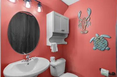 a bathroom with red walls and a sink and a mirror at The Bungalows at Seagrove 114 in Seagrove Beach