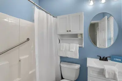a bathroom with a white toilet and a mirror at The Bungalows at Seagrove 114 in Seagrove Beach