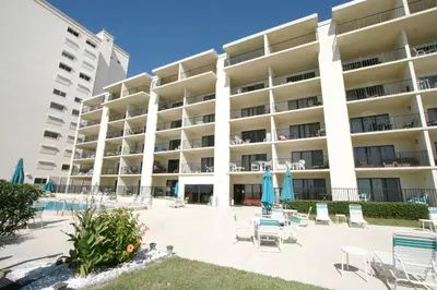 a large apartment building with chairs and a swimming pool at Mariner West 205 in Panama City Beach