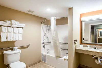 a bathroom with a toilet and a shower and a sink at Comfort Suites in Panama City Beach