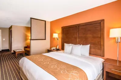 a large bed in a hotel room with orange walls at Comfort Suites in Panama City Beach