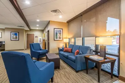 a lobby with blue chairs and a couch and a table at Comfort Suites in Panama City Beach