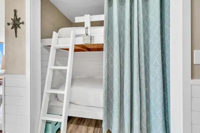 a bunk bed with a ladder in a small room at Edgewater Tower 2-611 in Panama City Beach
