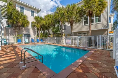 a swimming pool in front of a house with palm trees at 30A Beach House - Sanibel in Seagrove Beach