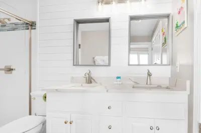 a white bathroom with two sinks and a toilet at Ocean Reef 1708 in Panama City Beach
