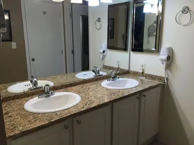 a bathroom with two sinks and two mirrors at Edgewater Beautiful 2 bedroom 2 bath! in Panama City Beach