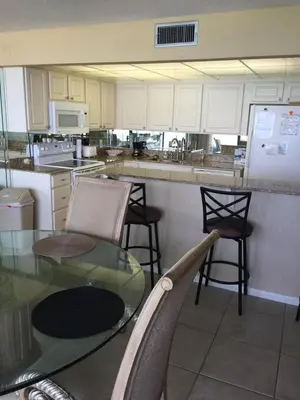 a kitchen with a glass table and some chairs at Edgewater Beautiful 2 bedroom 2 bath! in Panama City Beach