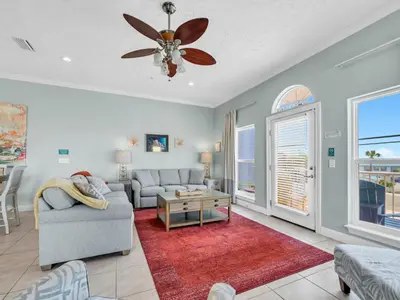 a living room with a couch and a ceiling fan at Vista del Mar I Rest-A-While 201 in Panama City Beach