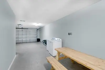 an empty room with a bench and a refrigerator at Vista del Mar I Rest-A-While 201 in Panama City Beach
