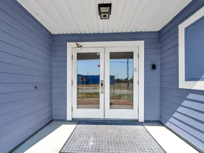 a blue house with a white door at Vista del Mar I Rest-A-While 201 in Panama City Beach