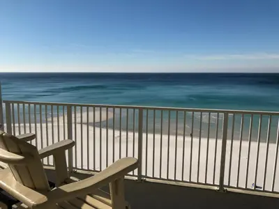 a chair sitting on a balcony looking at the ocean at Ocean Ritz - Family Tides - sleeps 12 in Panama City Beach