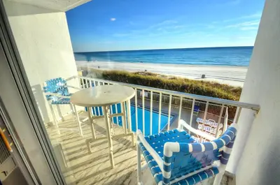 a balcony with a table and chairs and the beach at Emerald Villa in Panama City Beach