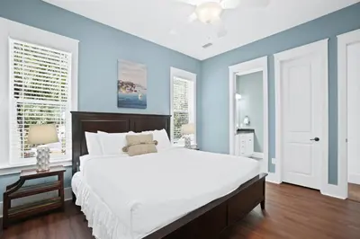 a bedroom with a large white bed and blue walls at 30A Beach House - Caspian Sea-duction in Sunnyside