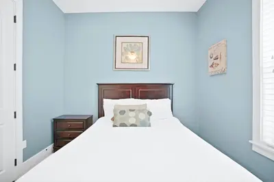 a bedroom with a white bed and blue walls at 30A Beach House - Caspian Sea-duction in Sunnyside